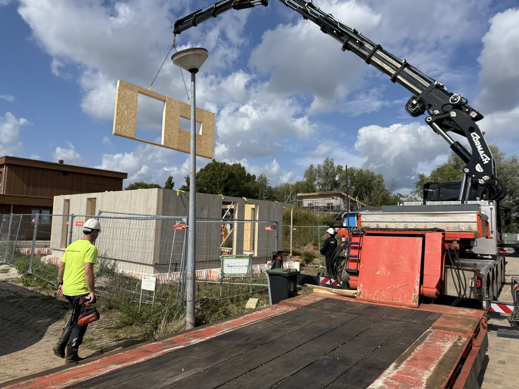 HSB-wandelement met kozijnuitsparing wordt op de bouwplaats gehesen door een kraanwagen