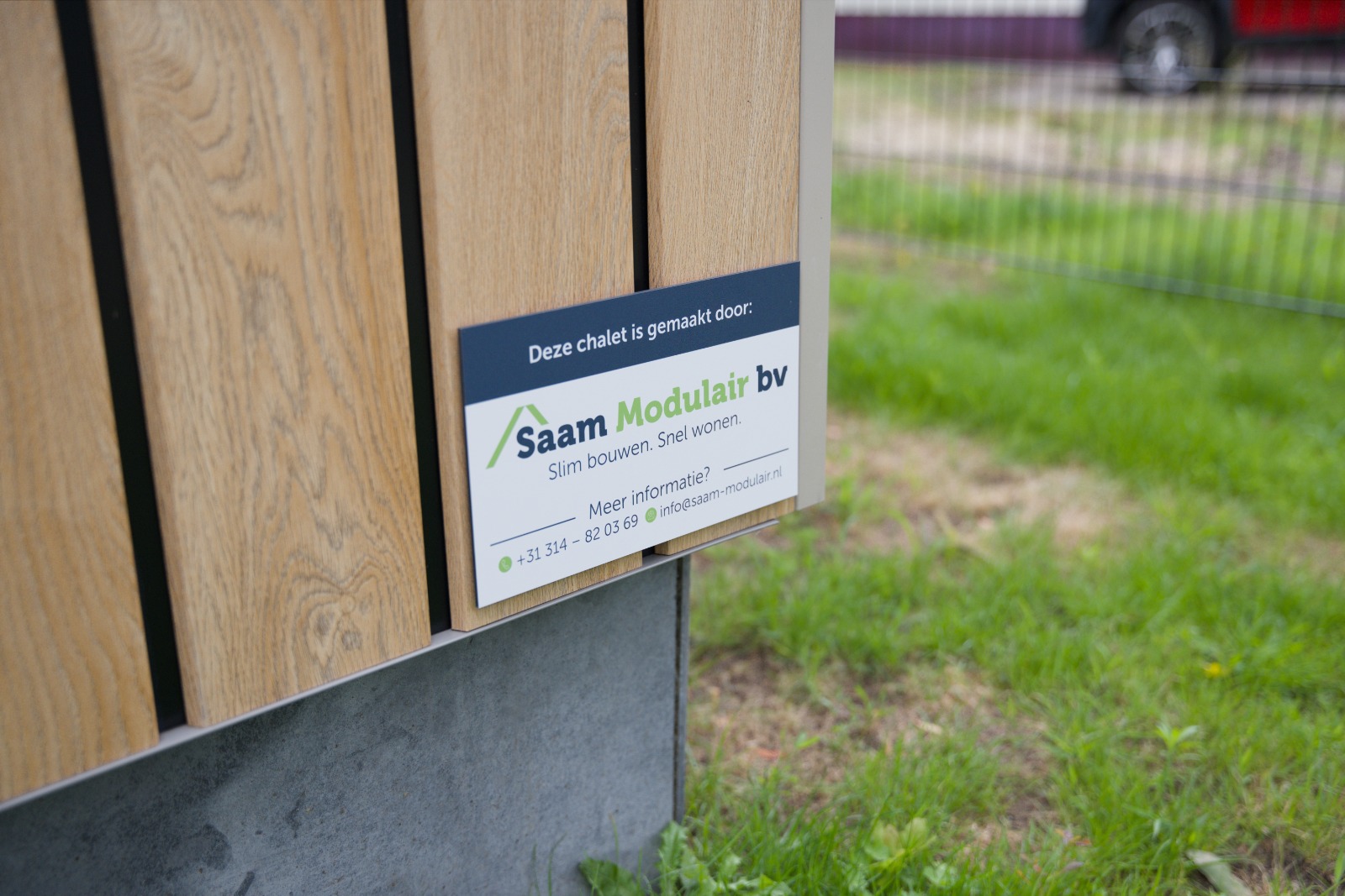 Detail van de houten gevelbekleding met naambordje van SaamModulair bij het rolstoeltoegankelijke vakantiechalet