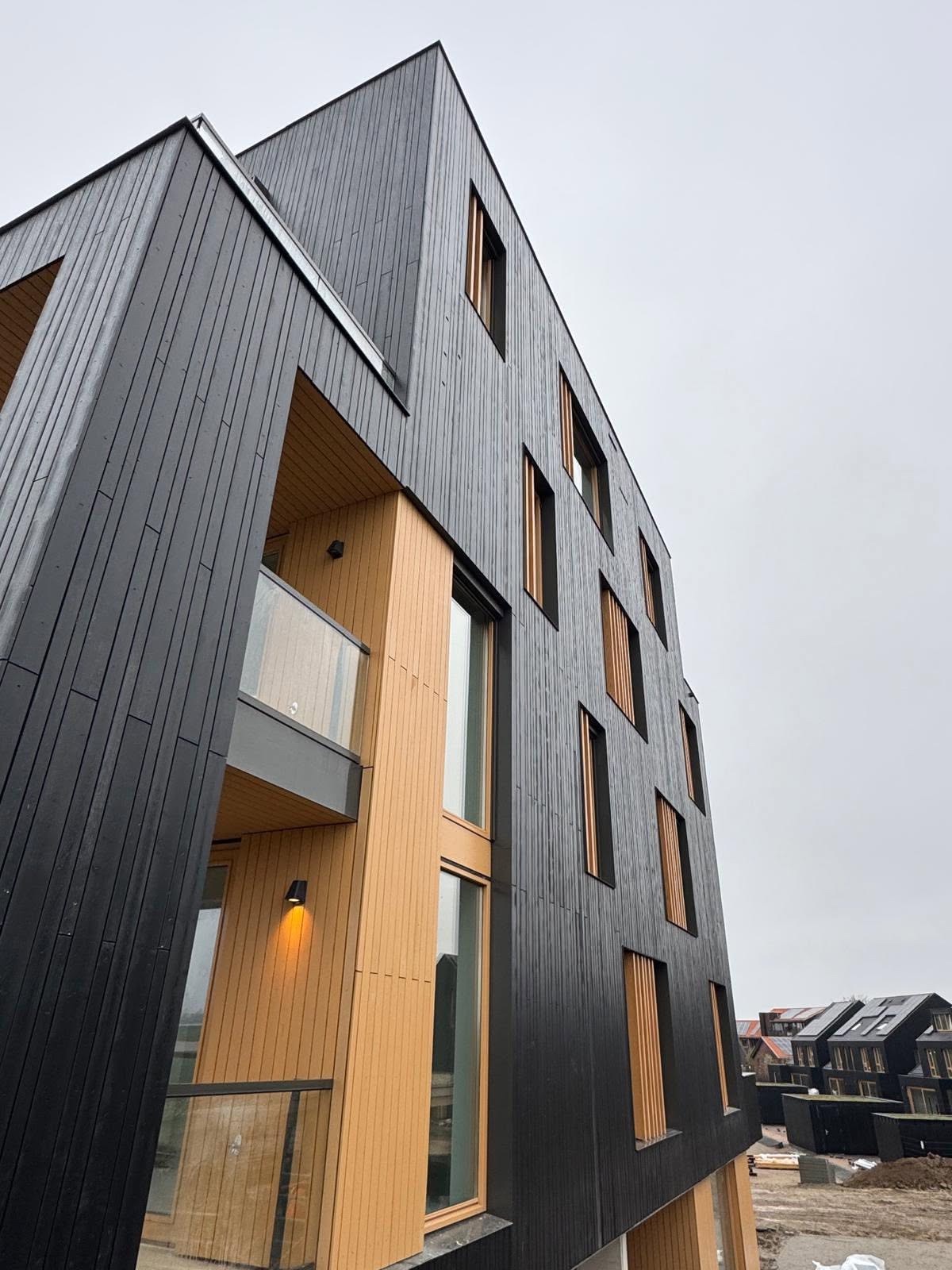 Detail van het appartementengebouw met vuren geveldelen bij project Stelt