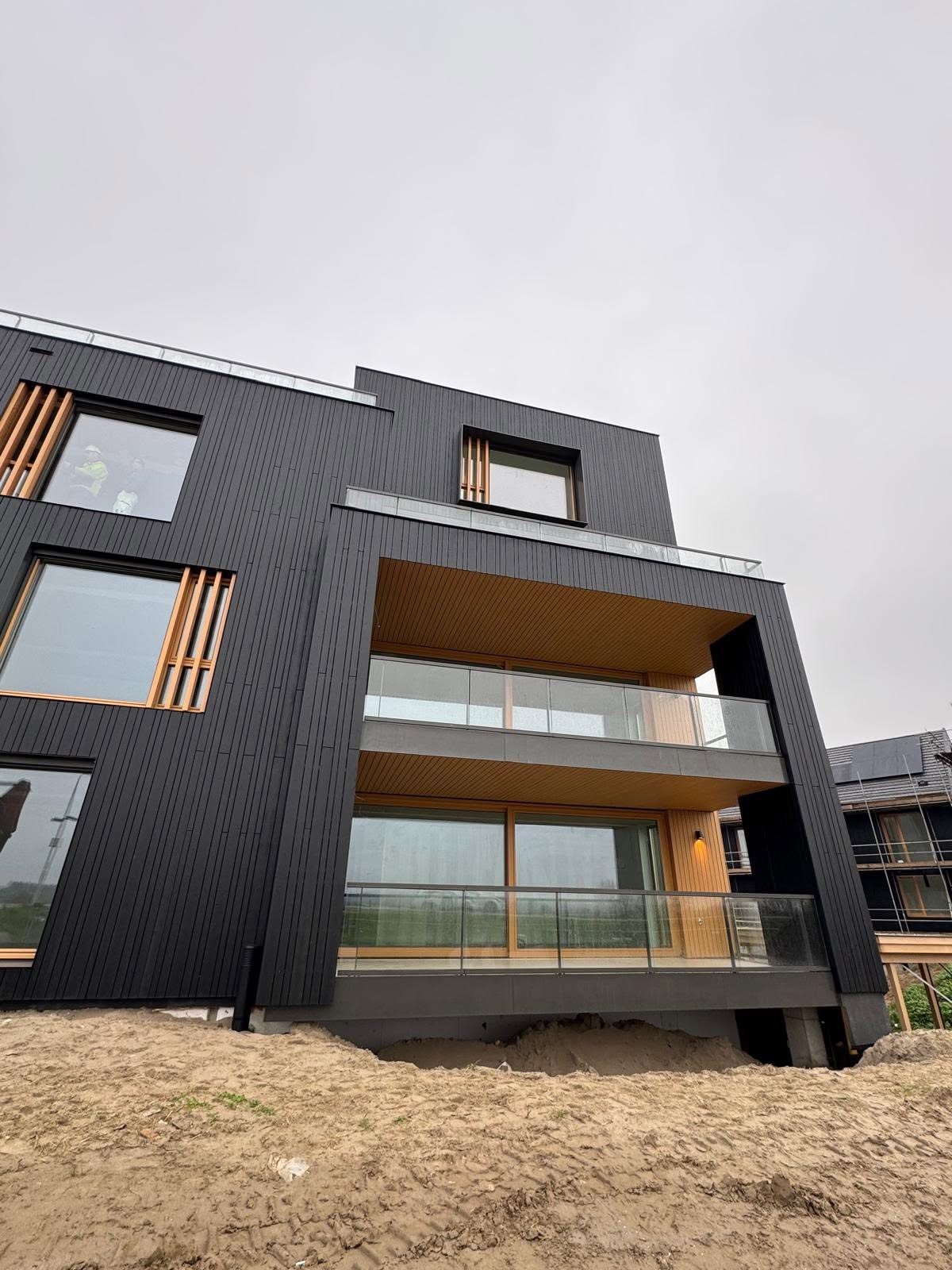Balkons en vuren gevelbekleding aan een appartementengebouw bij project Stelt